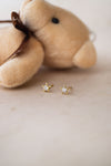  Sterling silver stud earrings with star and moon designs, displayed next to a plush toy.